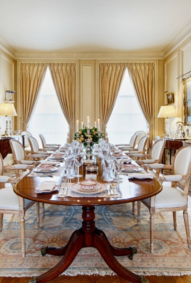 طاولة طعام كبيرة تعلوها إنارة كريستال تتدلى من السقف بشكل مميز