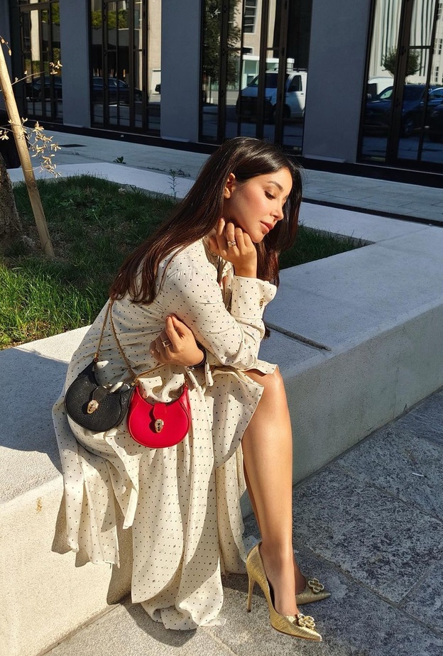 أطلت أسيل بفستان أبيض مزيّن بنقشة البولكا دوت من ماركة Fendi نسّقت معه حقيبة BVLGARI