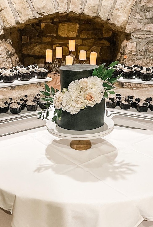 كعكة زفاف باللونين الأبيض والأسود تزينها أشكال فروع خضراء