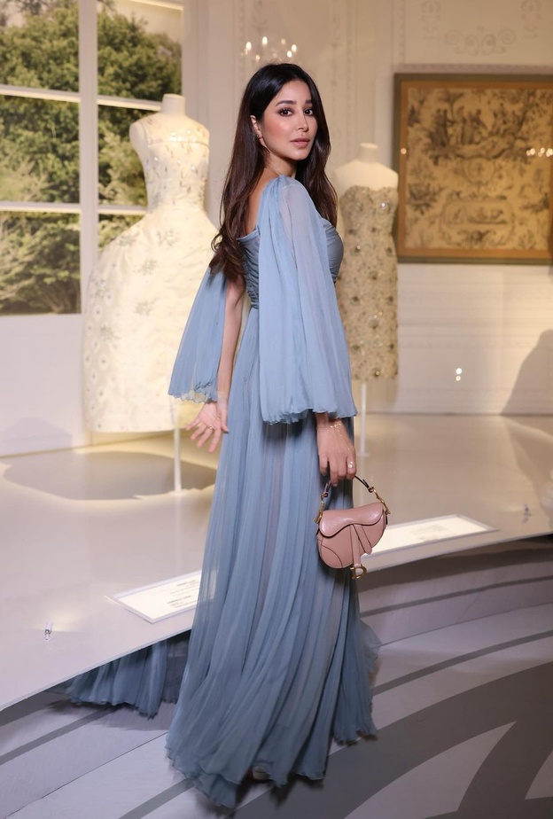 أسيل عمران بدت ساحرة بالفستان الأزرق الذي تميّز بقصة الصدر الدرابيه والتنورة المنسدلة بنعومة على الأرض