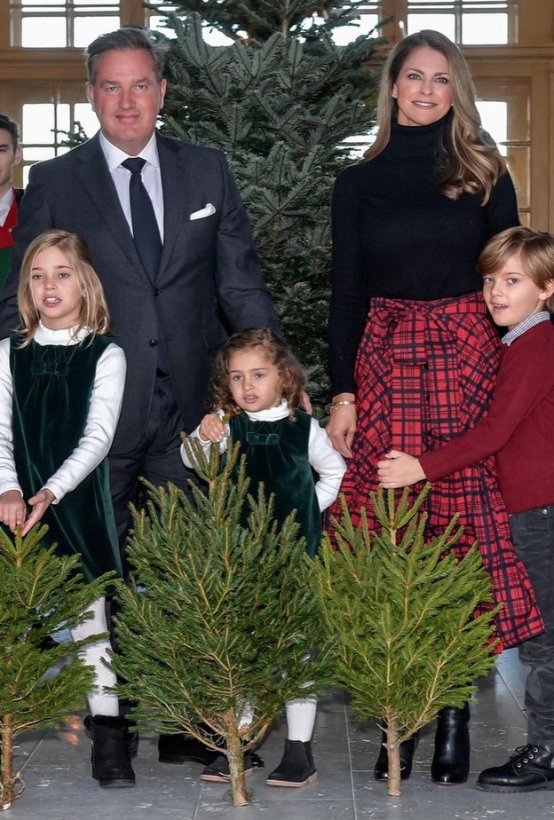 إختارت الكنزة السوداء ذات ياقة دائرية عالية مع تنورة ميدي باللون الأحمر مزيّنة بنقشة الترتان