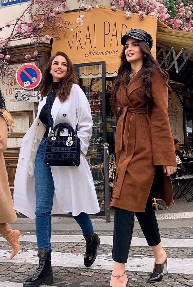 نسّقت الكنزة السوداء بياقة عالية مع البنطلون الدنيم وأكملت اللوك بمعطف أبيض