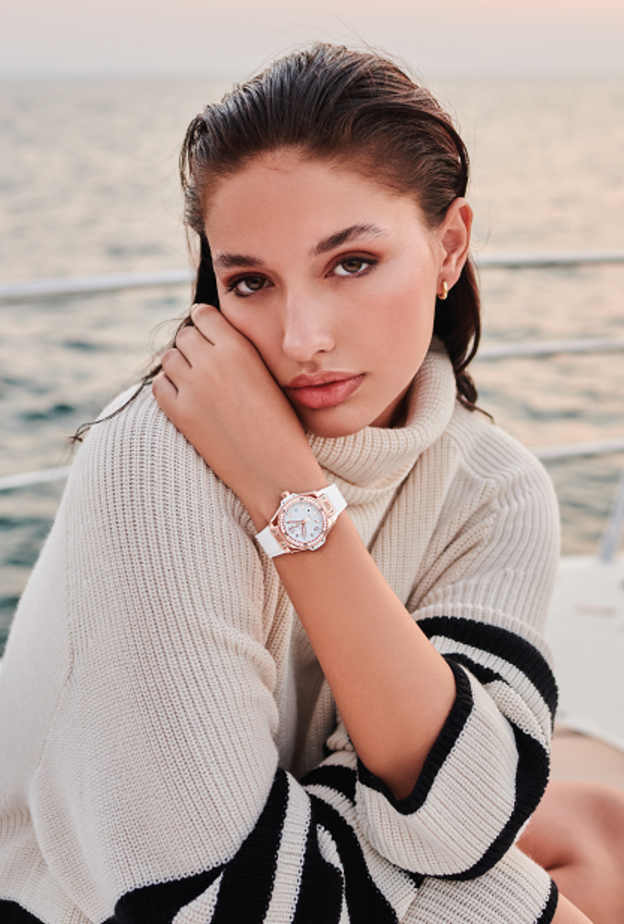 ساعة "بيغ بانغ وان-كليك" Big Bang One-Click بحزام مطاطي باللون الأبيض قابل للتبديل مع قطر 33 مم، وإطار مرصّع بحبات الماس. من دار "هوبلو" Hublot للساعات الفاخرة. إطلالة من "فالنتينو" Valentino.