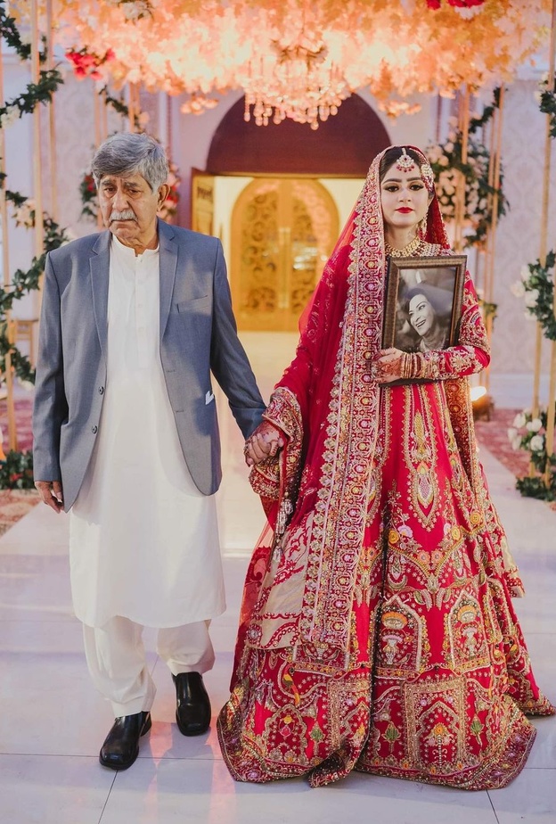 عروس تحمل صورة والدتها الراحلة في حفل زفافها