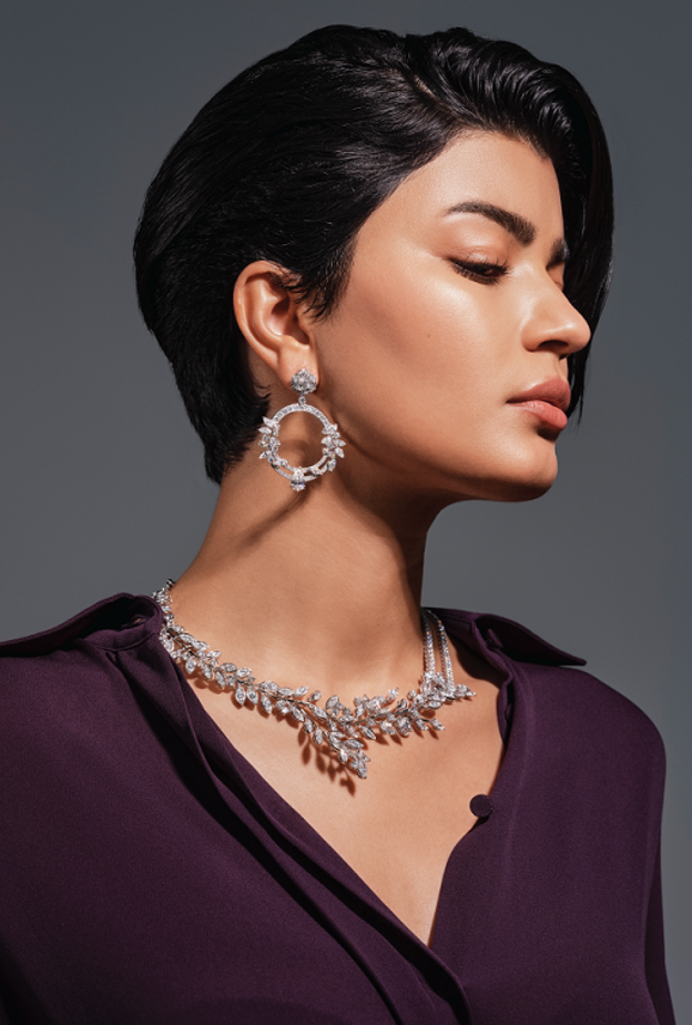 أقراط "لايملايت روز باشن" Limelight Rose Passion وعقد "لايملايت غاردن بارتي" Limelight Garden Party من الذهب الأبيض والماس من دار "بياجيه" Piaget للمجوهرات الفاخرة. قميص من تنسيق منسّقة الأزياء.