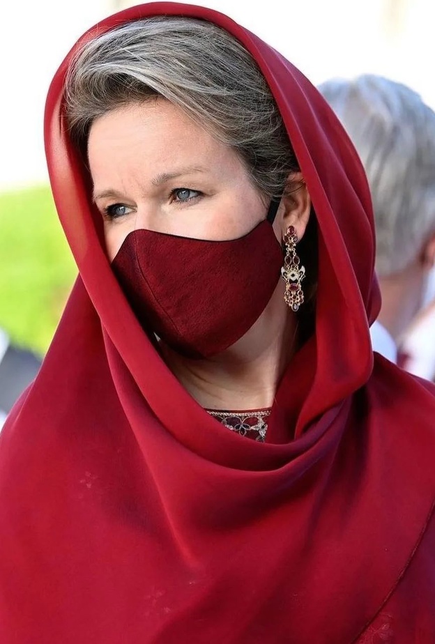 ملكة بلجيكا بإطلالة حمراء وغطاء رأس خلال زيارة مسجد السلطان قابوس