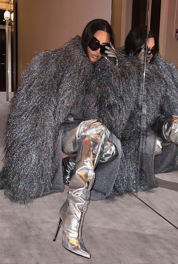 تألقت كيم بالمعطف الفضي نسقت معه فستان رمادي فاتح وجزمة ميتاليكية