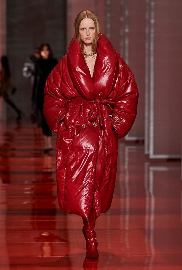 Versace جمعت بين التصاميم المنتفخة واللامعة في معطف أحمر مع الحزام ليحدد الخصر