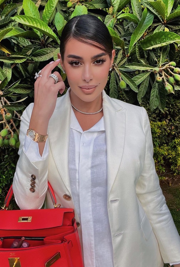 أطلت بالبليزر الأبيض الكلاسيكي التي نسّقت معه القميص الأبيض وحقيبة Hermes باللون الأحمر