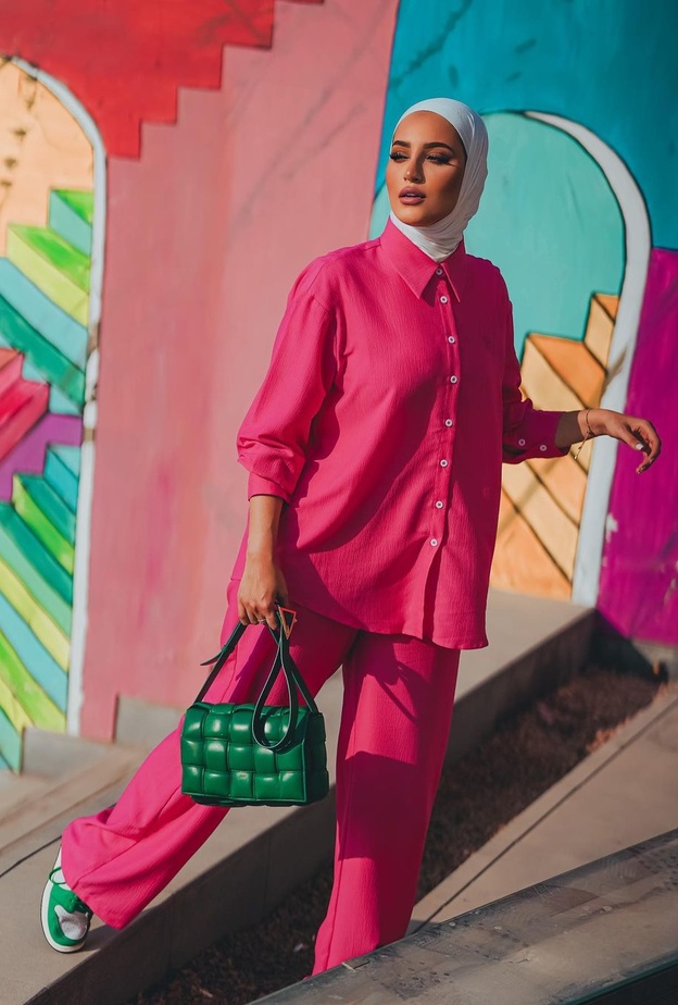 نسّقت دلال الدوب القميص الأوفر سايز مع البنطلون ذات القصة الواسعة وأكملت اللوك بحقيبة باللون الأخضر