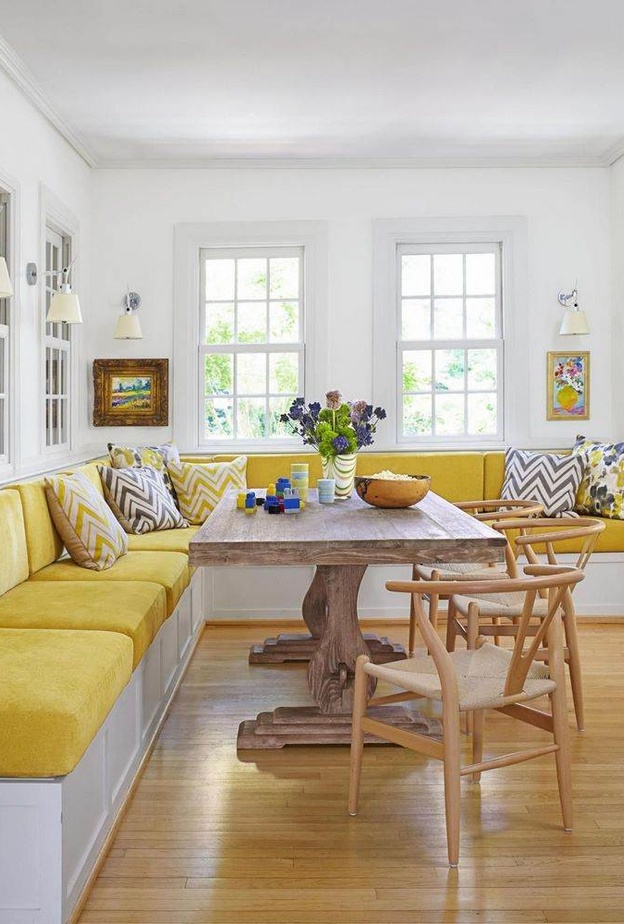 كنبة مطبخ بألوانة زاهية وطاولة وكراسي خشبية أنيقة