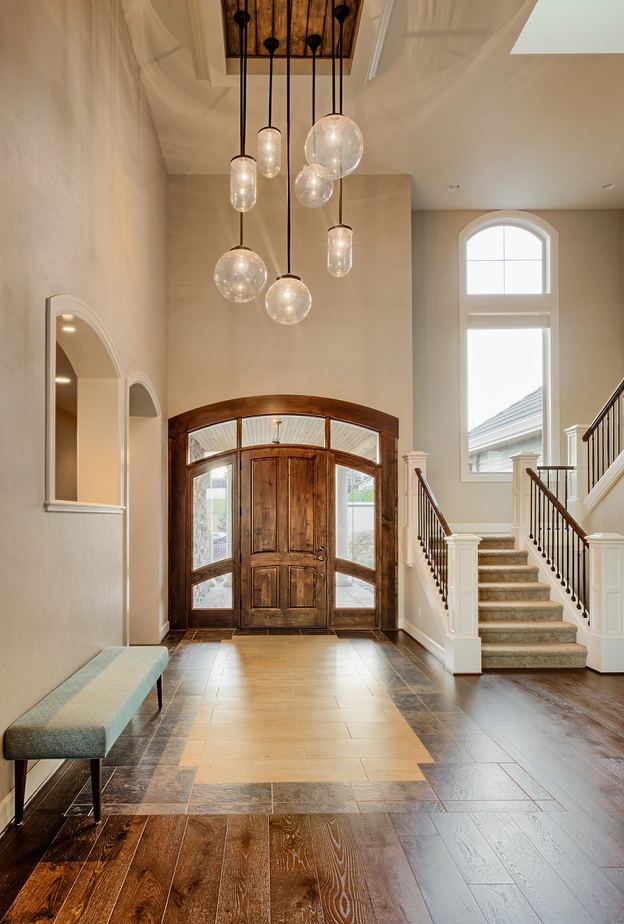 مدخل منزل مزين بمجموعة من الثريات الدائرية الرائعة