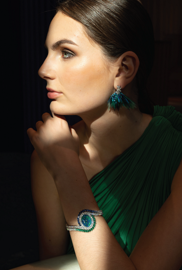 ساعة إكسترافاغنت تاتش Extravagant Touch تحفة فنية مرصعة بالماس والأوبال والزمرد والصفير والريش. يمكن نزع زينة الريش لتتحول إلى أقراط.