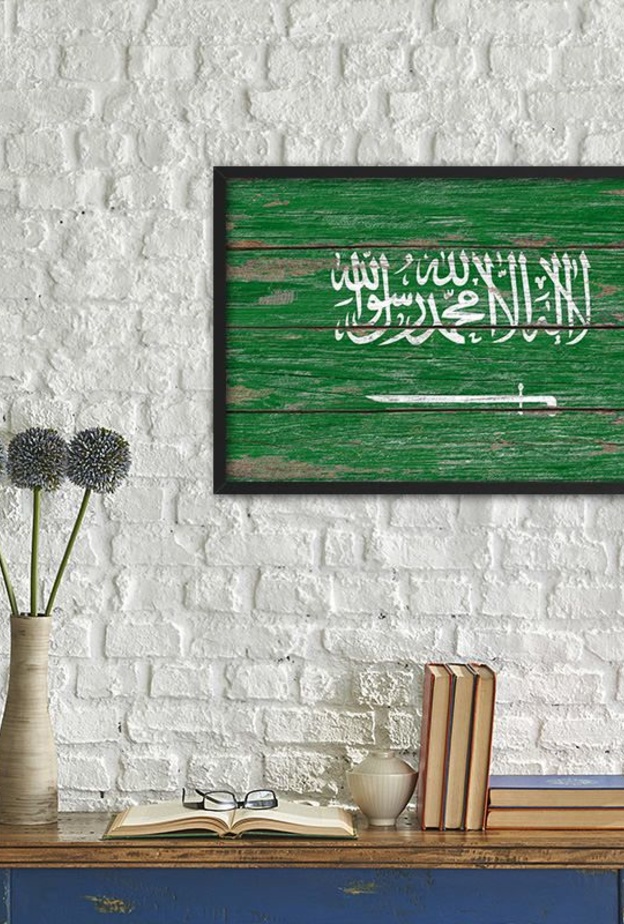 العلم السعودي على جدران المنزل الحجري