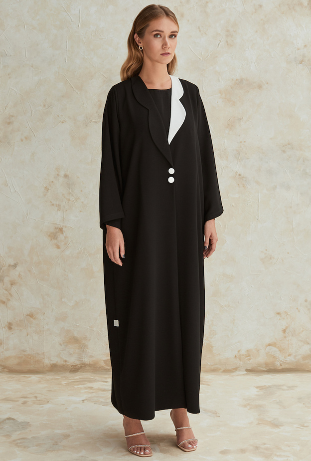 عباية سوداء بتفاصيل جذابة وشبابية بالقبّة باللونين الأسود مع الأزرار البارزة من WA Dubai 