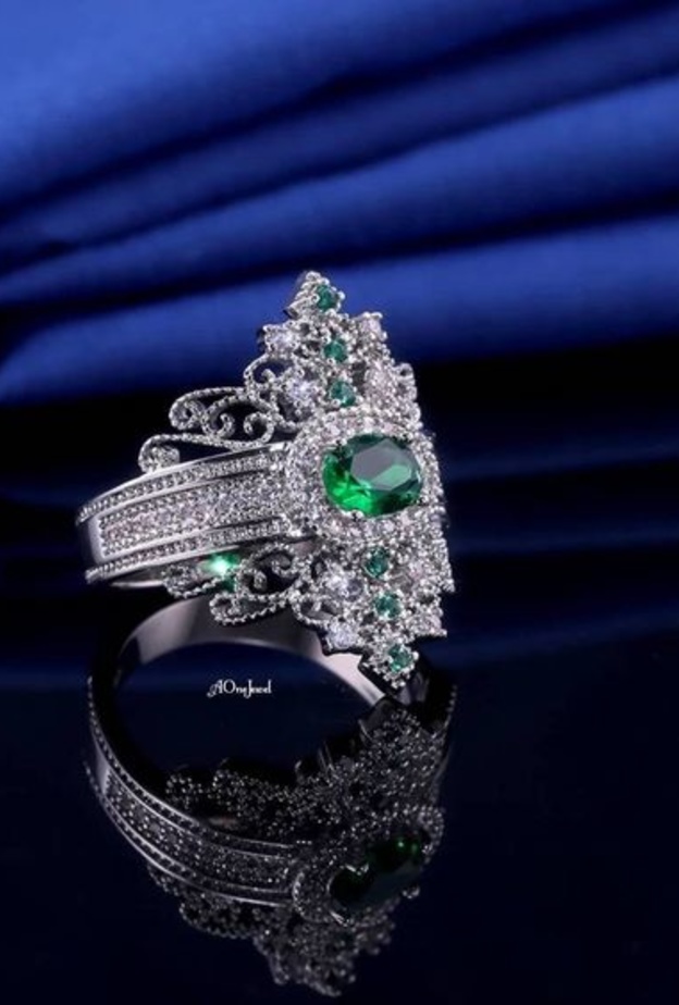 خاتم خطوبة على شكل تاج مصري مرصوف بالزيركون الصغير.