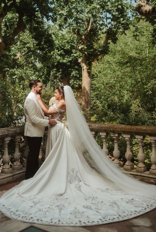 اختارت مينا الشيخلي فستان زفاف بقصة ملكية مع طرحة طويلة