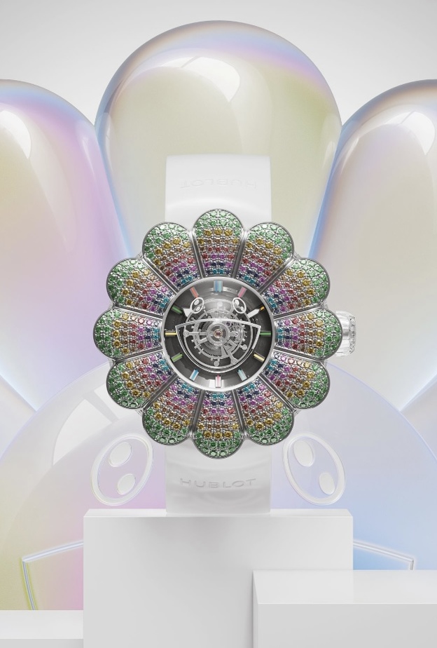 Hublot تقدم ساعة Takashi Murakami.. أول ساعة بتوربيّون مركزي سريع الحركة  ماريا شربل  قدّمت دار هوبلو Hublot ساعة MP-15 Takashi Murakami بتوربيّون مركزي سريع الحركة مصممة بالياقوت، فهذه القطعة فريدة من نوعها ويُمكن‭ ‬اعتبار ‬التوربيّون‭ ‬المركزي‭ ‬تجسيدًا‭ ‬لسعي‭ ‬Hublot‭ ‬إلى‭ ‬إعادة‭ ‬تسليط‭ ‬الضوء‭ ‬على‭ ‬الساعات‭ ‬الراقية. وتم تصميم هذه الساعة لتعرض في مزاد Only Watch العلني، ‬كما‭ ‬يُمكن‭ ‬تشبيه تصميم الساعة ‬الدائريّة‭ ‬برسمة‭ ‬طفل‭ ‬صغير لزهرة الربيع باثنتي عشرة بتلة،‭ ‬ذات أطراف خضراء كدلالة على الأ