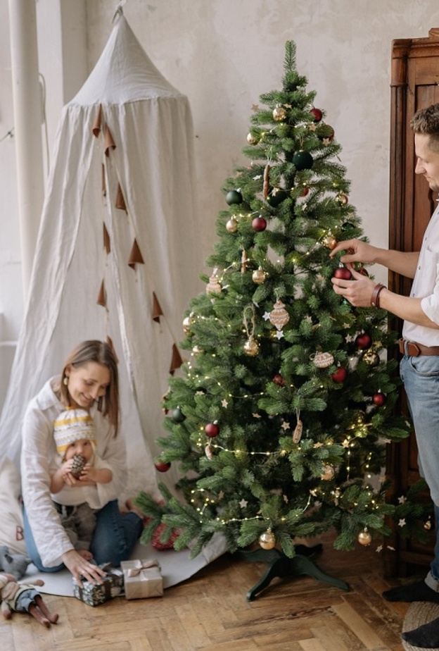 أسرة تقوم بتزيين شجرة عيد الميلاد