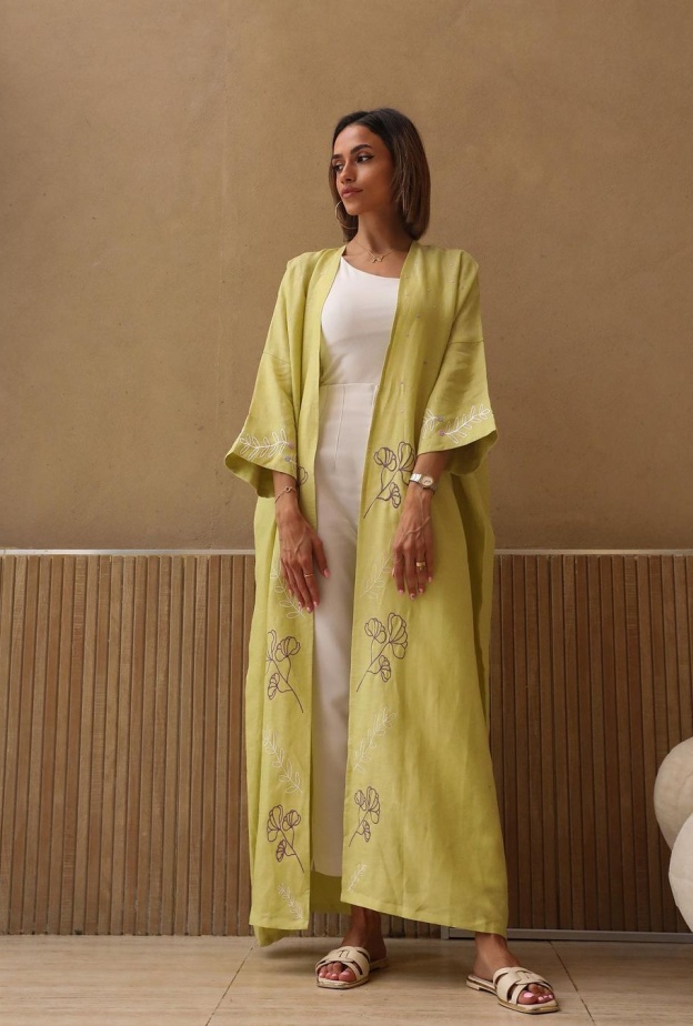 عباية صفراء بزهور بيضاء محددة على الأكمام تضفي لمسة من الرقي