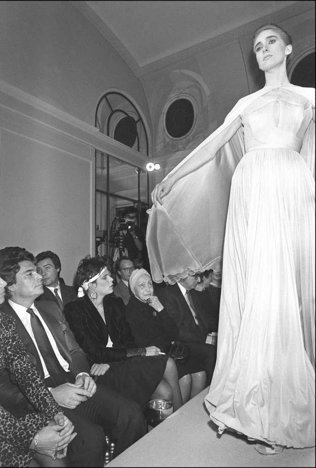 التقطت الصورة في 24 مارس 1985 في باريس لعارضة أزياء أثناء عرض مجموعة الملابس الجاهزة لخريف وشتاء، تحت أنظار المصممة الفرنسية مدام غراي (في الوسط)، في متجرها الواقع في شارع لا بيه في باريس. الصورة من موقع AFP