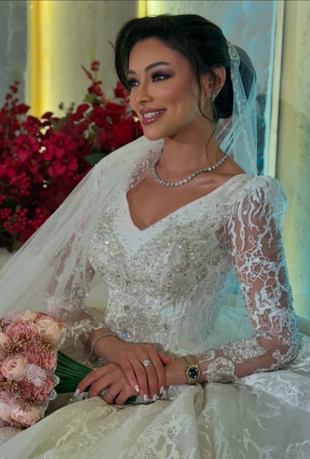 شوق الهادي أول عروس في مسلسلات رمضان 2025..كيف بدت إطلالتها؟  عندليب دندش الإطلالات الأنيقة التي تتميز بها الفنانة الكويتية شوق الهادي إنعكست على رقي إختيارها في إطلالتها العرائسية في المسلسل الرمضاني لعام 2025 أبو البنات، إذ توجهت لاختيار فستان زفاف بموضة القصات المنفوشة ذات التنورة الضخمة والقماش المطرز بالترتر على عكس فستان زفافها في مسلسل أمينة حاف الذي عُرض في رمضان 2021 والذي اعتمد على قماش الساتان وجاء بتفاصيل جداً بسيطة وناعمة باستثناء اليدين التي تم إدخال حركة إليهما على هيئة خيوط لامعة تربط أسفل ا