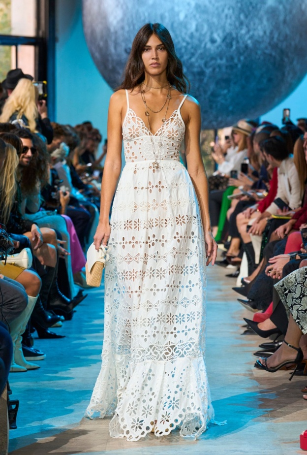 فستان أبيض بوهيمي وحقيبة من القش من مجموعة إيلي صعب ربيع صيف 2024