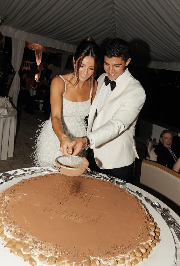 عروسان يقومان بتزيين الكيك مباشرة ليلة الزفاف أمام الضيوف