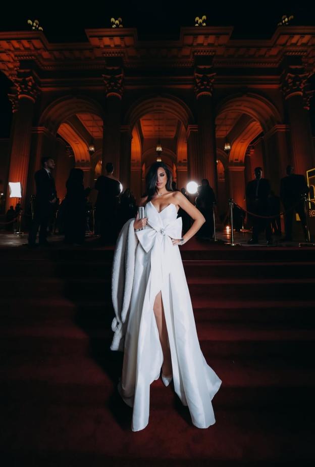 إلهام وجدي بفستان سهرة طويل باللون الأبيض مميز بقصة سترابلس