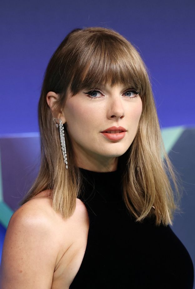 إطلالة Taylor Swift برسمات المكياج البني البراق مع أحمر الشفاه المشمشي