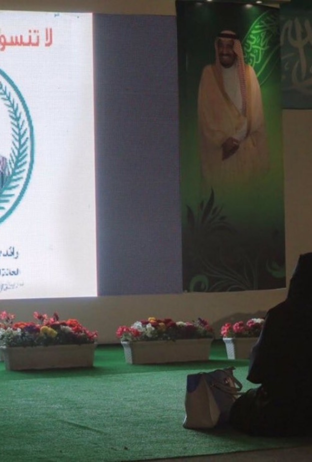 قريبة الشهيد محمد أحمد العنزي تجلس أمام صورته في الجنادرية