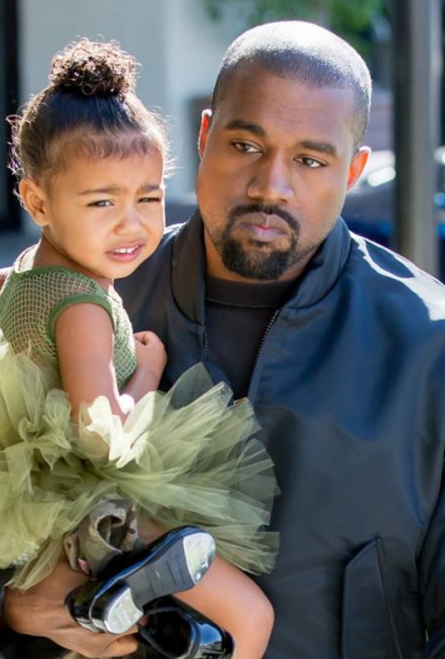 كاني يحمل ابنته وهو حزين