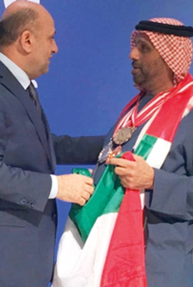 أحمد مجان المخترع الإماراتي متوشحاً بعلم وطنه الحبيب