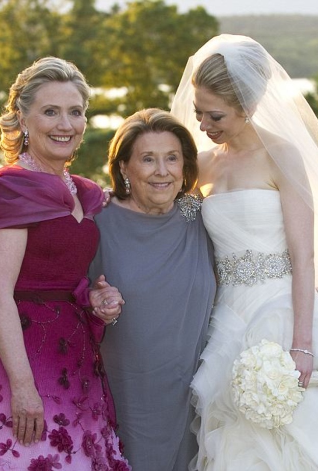 المرشحة على الانتخابات الرئاسية الاميركية هيلاري كلينتون تفاجئ الجميع بالفستان الذي اختارته في زفاف ابنتها تشيلسي من اللون Rosebush ومطرز من الورود النافرة وبتصممي ملفت على العنق