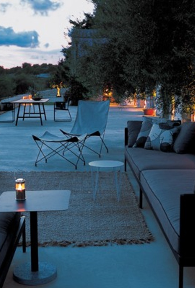 من تصميم Gordon Guillaumier، اخترنا لك جلسة خارجية مودرن بألوان داكنة لجلسة مسائية خاؤجية دافئة.