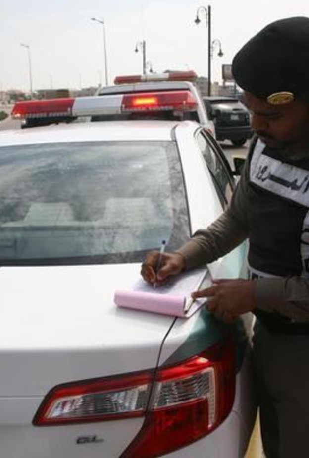 رجل مرور سعودي يقوم بتحرير مخالفة 