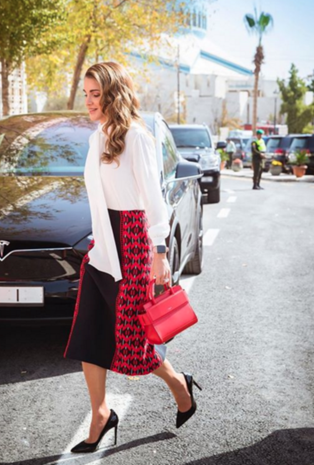 فستان ذو تصميم أنثوي باللون الزهري اختارته الملكة رانيا ونسقته مع حقيبة يد من فندي