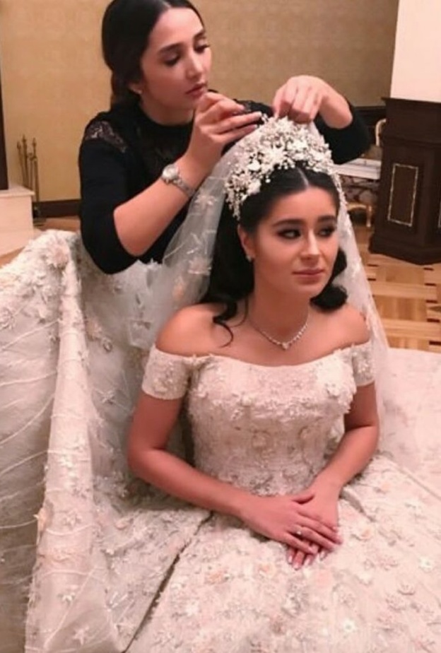 نسقت العروس الروسية طرحة طويلة فخمة مع فستان الزفاف