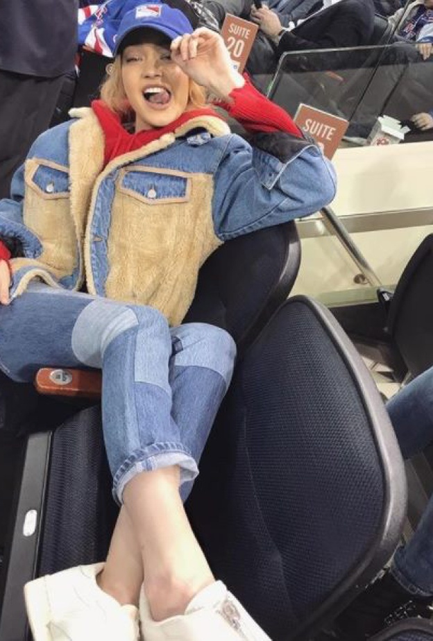 جيجي حديد تتخذ وضعية رشيقة أثناء تشجيعها لفريق نيويورك رينجرز في مباراة هوكي