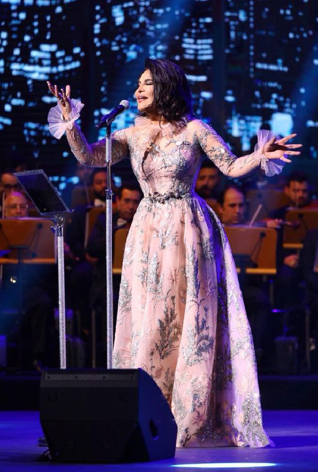 تميّز الفستان بأكمامه الطويلة والكشاكش التي زيّنت الاكمام والياقة