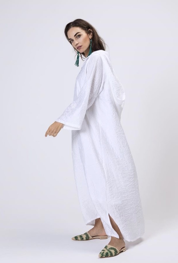 قفطان أبيض مع حزام طويل باللون الأخضر محكم بحلقة معدنية .
