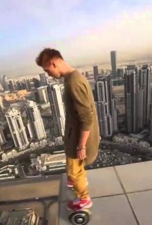 مغامر يؤدي حركات خطيرة فوق أحد أبراج دبي