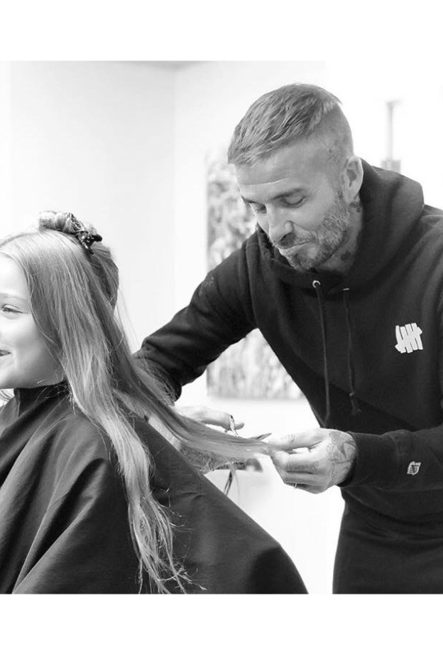 يبدو ديفيد بيكهام متأثرا وهو يقص الخصلات الطويلة لشعر ابنته هاربر