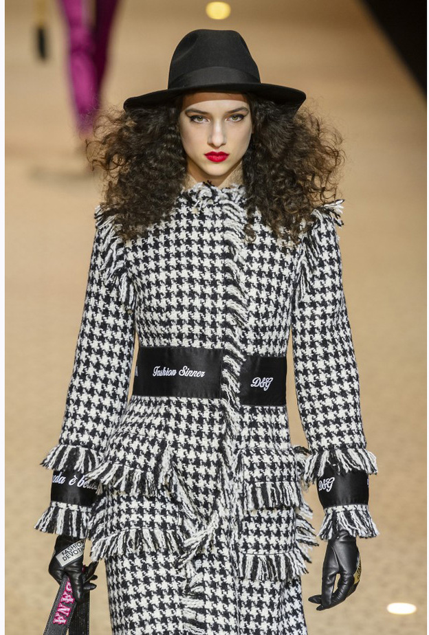 صورة مقرّبة للمعطف بالأسود والأبيض المكلّل بشراشيب باللون الأسود