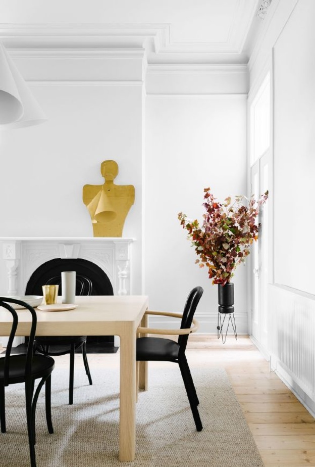 ثريات رائعة باللون الذهبي تبرز جمال غرفة الطعام بلونها الأبيض