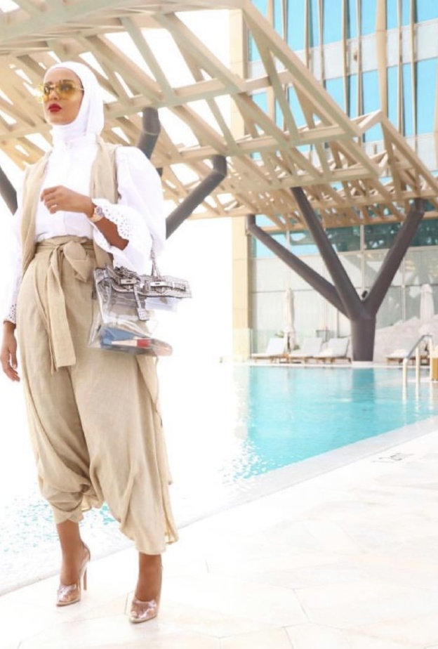 نسقي القميص الزهير مع البنطلون الأبيض وحقيبة من ديو