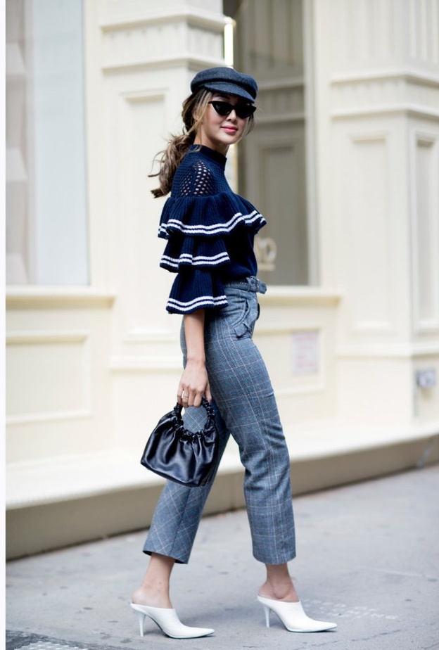 اختاري توب أنيقة باللون الأسود مزينة بالكشكش مع بنطلون الجينز.