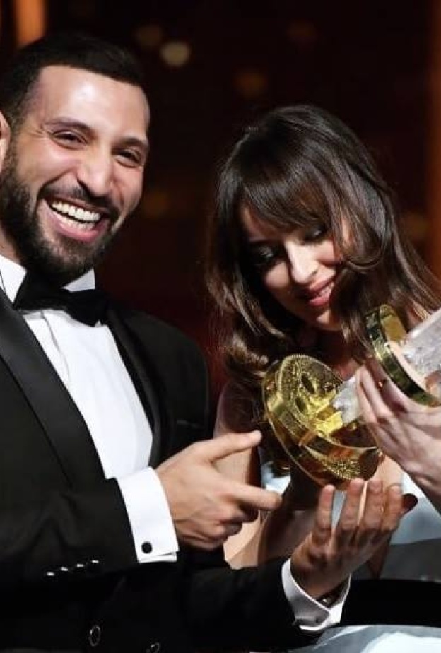 لقطة ضاحكة بين داكوتا جونسون والتونسي نضال السعدي أثناء تسليمه جائزة أفضل ممثل في اختتام مهرجان مراكش للفيلم
