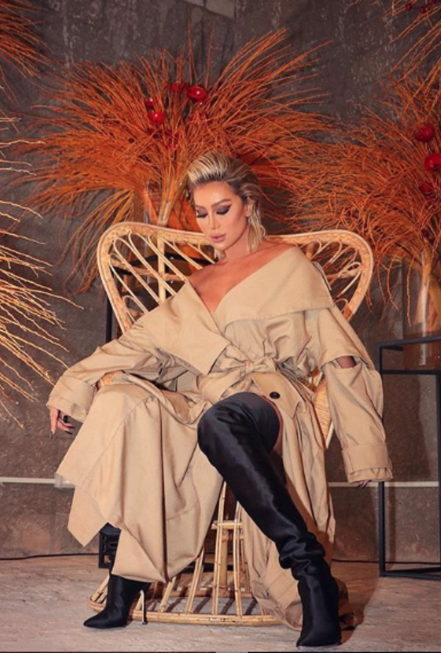 اطلالة عصرية وجذابة لمايا دياب بالترينشكوت بلون البيج مع الحذاء الشتوي العالي باللون الأسود