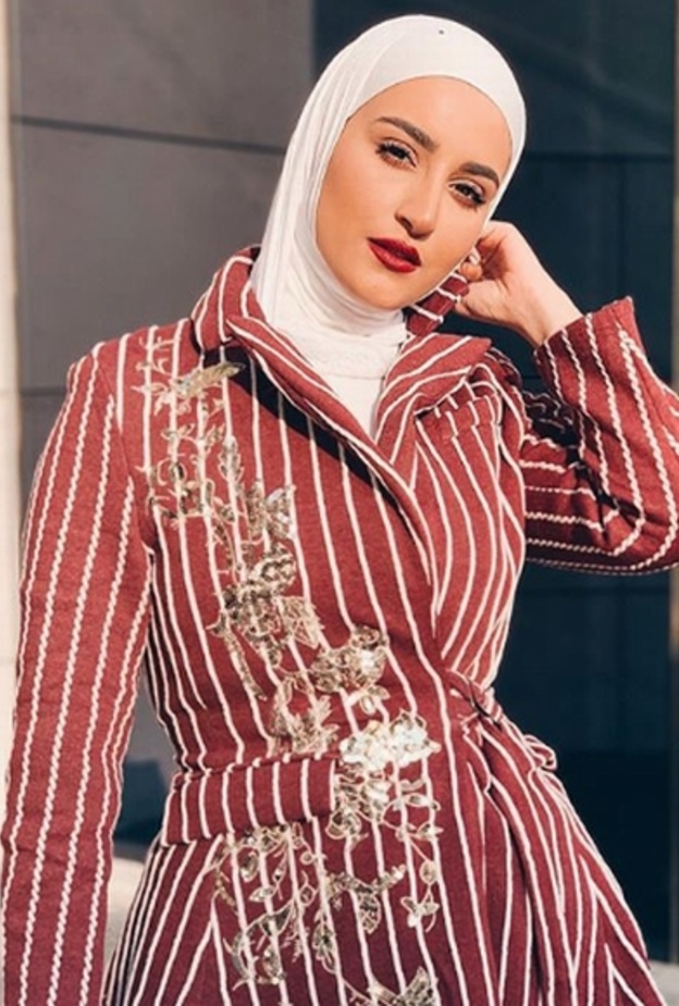 اختارت دلال الدوب بليزر أسود أنيق مع حزام ونسّقته مع حجاب أبيض مزيّن بلمسات ناعمة